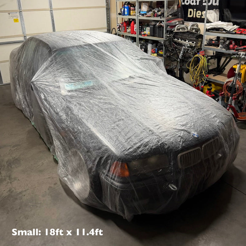 Car covered with a clear plastic in a garage.